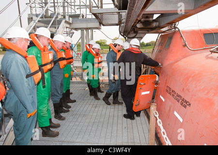 Workers in the offshore industry practice escaping in an emergency life boat as part of an industry training course, Stock Photo