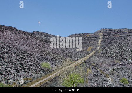 Paraglider above the horizon, near an A5 incline at Dinorwig slate mine, Snowdonia, North Wales, UK Stock Photo