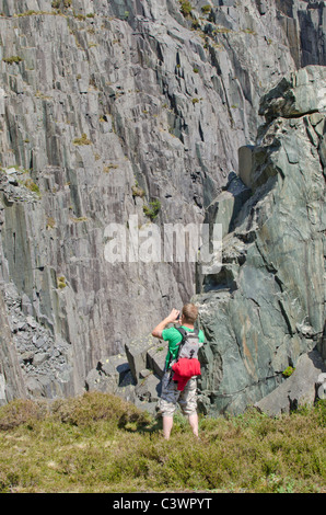 Young man taking a photo with a mobile phone of the main groove on The Quarryman, Dinorwig slate mine, Snowdonia, North Wales Stock Photo