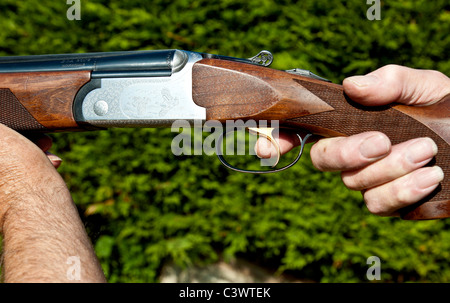 man holding shotgun with finger on the trigger.landscape format.copy space. Stock Photo