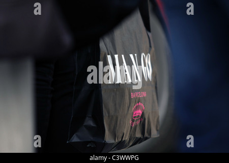 A side view of a Mango shopping bag being carried in London Stock Photo