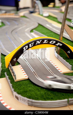 A large toy scalextric track with model cars going round the electric circuit England UK Stock Photo