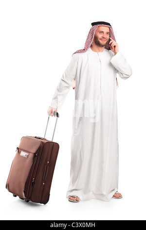 Arab tourist carrying a suitcase and talking on a mobile phone isolated on white Stock Photo