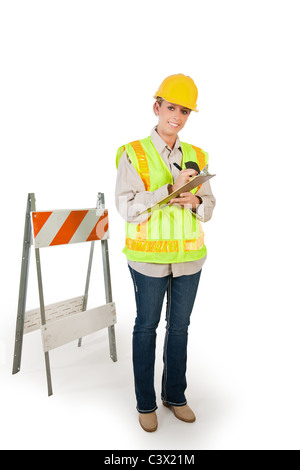 a young female construction worker filling out her paperwork using a clipboard Stock Photo