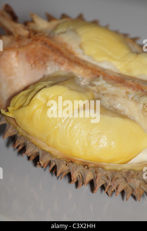 Durian fruit cut in half on a wooden table. The durian is the edible ...