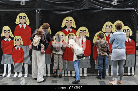 Members of the public take i peep inside one of the performance tents at Brighton Festival 2011 Fringe Streets event UK Stock Photo