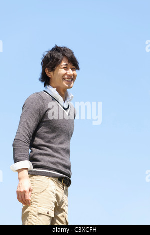 Young Man Against Blue Sky Stock Photo