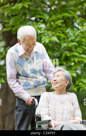 Senior Man Pushing Wife in Wheelchair Stock Photo