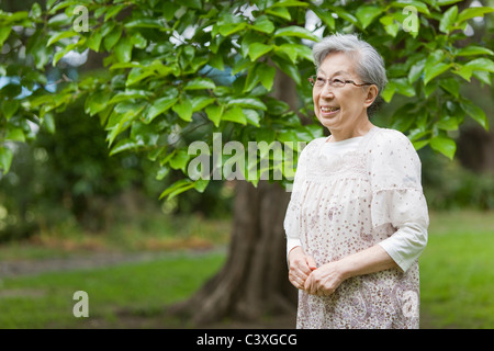 Senior woman standing and smiling, Tokyo Prefecture, Honshu, Japan Stock Photo