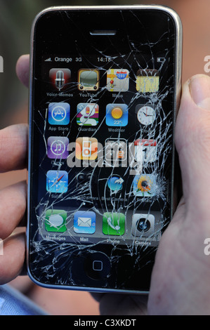 english man with a smashed iphone in the street Stock Photo