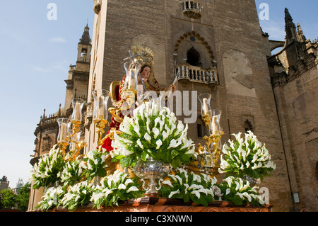 A paso of the Virgin Mary carried in a religious procession past the Cathedral in Seville, Southern Spain. Stock Photo