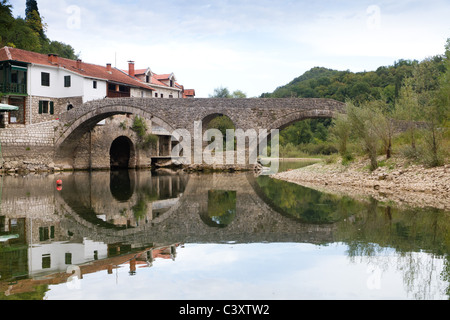 old bridge in the village Rijeka Crnojevica reflecting in the water in Montenegro Stock Photo