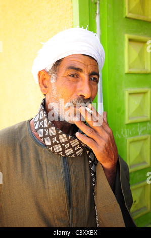 Africa Middle East Egypt Egyptian man in turban 40's 50's smoking a cigarette tobacco Stock Photo