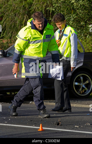 Police crash investigators at the scene of a collision between a bus and a car Stock Photo