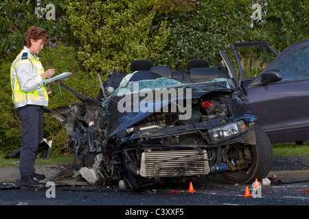 A police crash investigator at the scene of a collision between a bus and a car Stock Photo