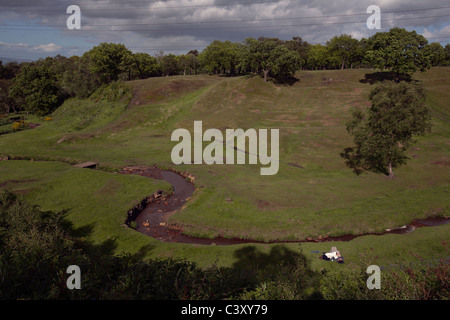 a couple liedown at rough castle antonine wall roman fort near falkirk in scotland Stock Photo