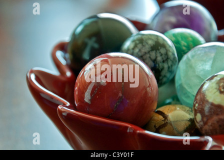 This stock image shows two white crosses reflected in a bowl of large, glass marbles. Background intentionally blurred. Stock Photo