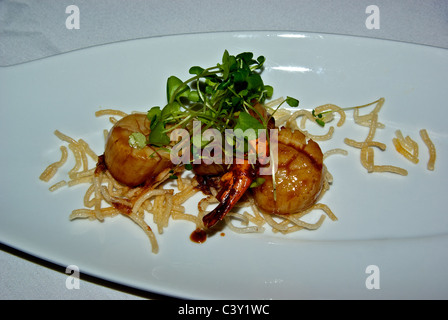 Grilled prawn scallop appetizer with deep fried vermicelli vegetable sprout garnish Stock Photo