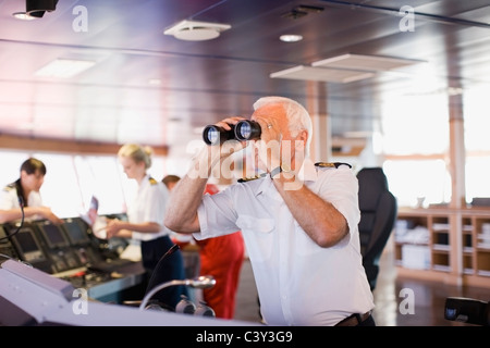 Captain on ship looking through a telescope Stock Photo