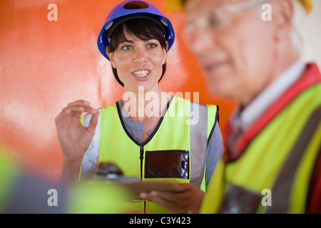 Female architect talking to builders Stock Photo