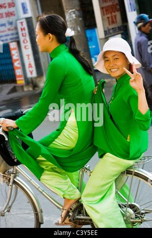 Two students in Ao Dai on bicycle Stock Photo