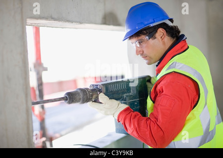 Building worker handling a power drill Stock Photo