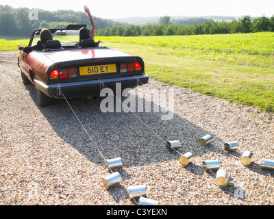 Freshly married couple in car, goodbye Stock Photo