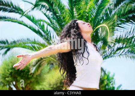 Beautiful young woman relaxing in tropical setting. Stock Photo