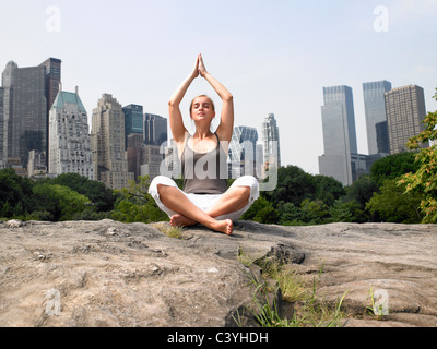 Woman doing yoga in central park Stock Photo