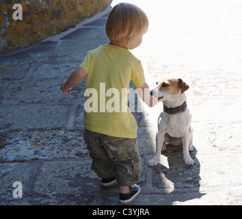 Baby boy playing with a dog Stock Photo