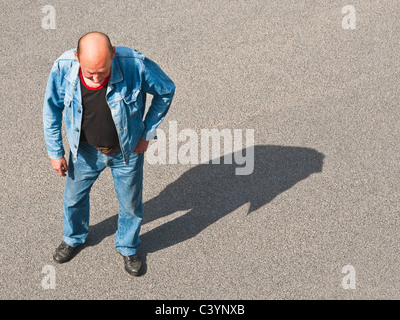 Overhead view of man in Denims walking across street - France. Stock Photo