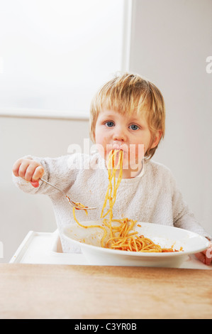Messy baby boy eating spaghetti Stock Photo