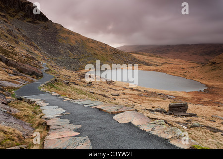 The Miners' Track footpath winding around Llyn Teyrn on the descent from Mount Snowdon, Snowdonia Stock Photo