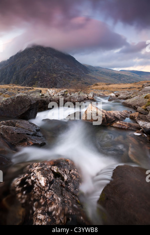 Rocky river in Cwm Idwal leading to Pen yr Ole Wen Mountain at sunset, Snowdonia National Park, Conwy, North Wales Stock Photo