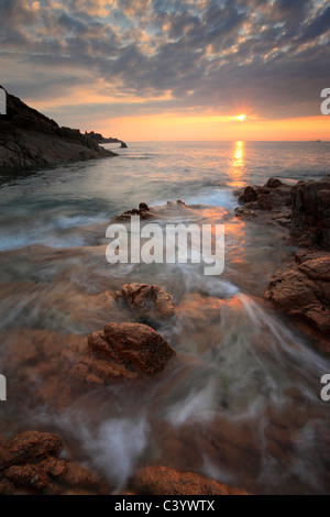 Sunset hues on the red rocks of Point aux Malades on the west coast of Guernsey in the Channel Islands of England Stock Photo