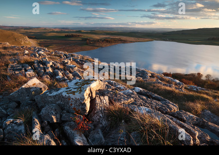 Sky and clouds reflect in the still waters of Malham Tarn in the Yorkshire Dales of England Stock Photo