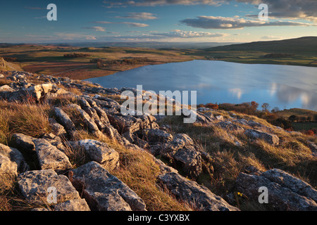 Sky and clouds reflect in the still waters of Malham Tarn in the Yorkshire Dales of England Stock Photo