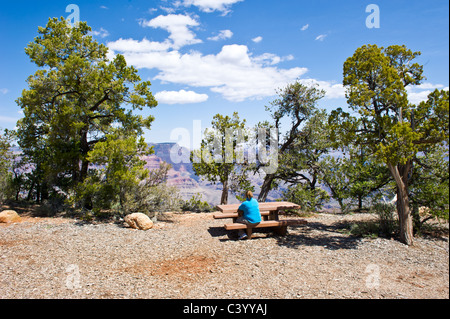 Woman sitting at a picnic table at Shoshone Point, Grand Canyon National Park in Arizona USA. Stock Photo