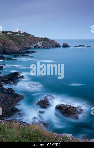 View from Lizard Point over rocky Polpeor Cove and onto the Lizard Lighthouse and old lifeboat Station, Lizard, Cornwall Stock Photo