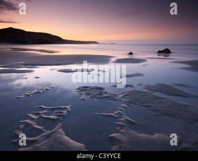 Water pools on the sandy beach at Kennack Sands at sunrise, Lizard Peninsula, Cornwall, England. Spring (May) 2011. Stock Photo