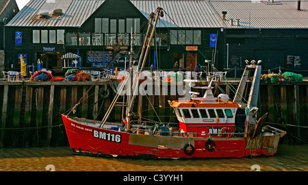 WHITSTABLE, KENT, UK - APRIL 30, 2011: Fishing trawler in front of Fish Market in Whitstable Harbour Stock Photo