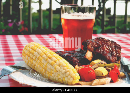 Perfect Holiday BBQ, complete with baby back ribs, corn on the cob, vegetables, and a wonderful wheat pale ale. Stock Photo