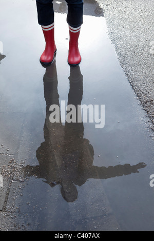 Reflection of a woman in a puddle Stock Photo
