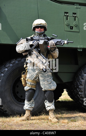 Army enthusiast wearing desert camouflage combat battledress and weapon replicas Stock Photo