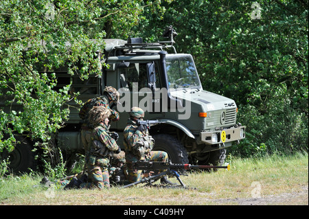 Belgian infantry soldiers firing Mi .50 machine gun near U1350L Unimog armoured fighting vehicle, Belgium Stock Photo