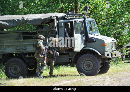 Demonstration of infantry soldiers fighting near U1350L Unimog armoured fighting vehicle of the Belgian army, Belgium Stock Photo