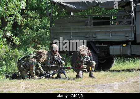 Belgian infantry soldiers armed with Mi .50 machine gun fighting near U1350L Unimog armoured fighting vehicle, Belgium Stock Photo