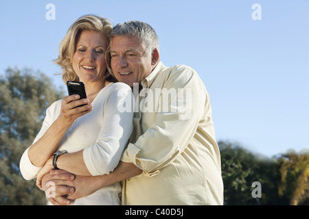 Mature couple using smart phone together Stock Photo