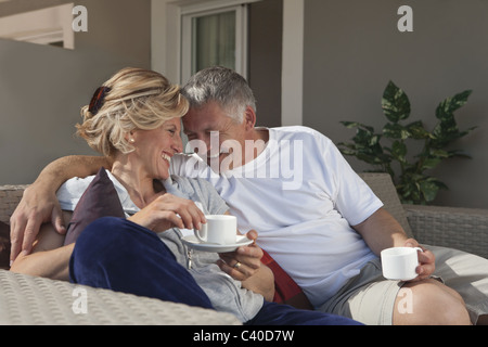 Mature couple drinking coffee on terrace Stock Photo
