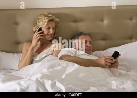 Mature couple in bed using smart phones Stock Photo